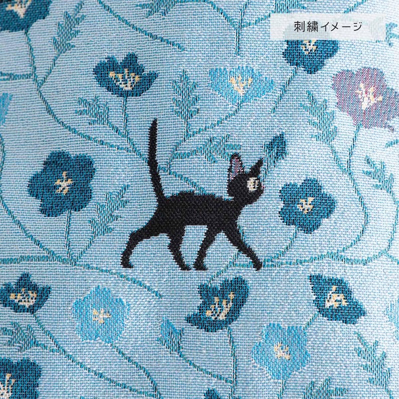 May include: A light blue fabric with a repeating pattern of blue flowers and vines. A black cat is embroidered on the fabric, walking among the flowers. The text "Embroidery Image" is in the upper right corner.