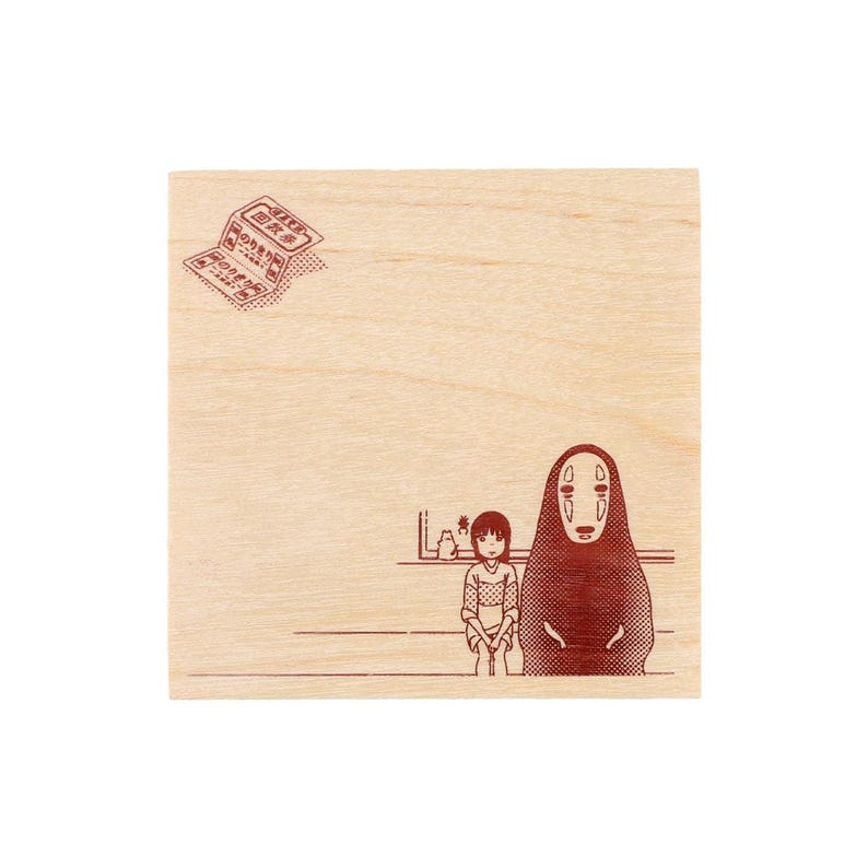 May include: A square wooden block featuring a dark red printed illustration of a character with a mask and a person sitting together. In the upper left corner, there is a small printed graphic of a ticket with Japanese text and dot patterns.