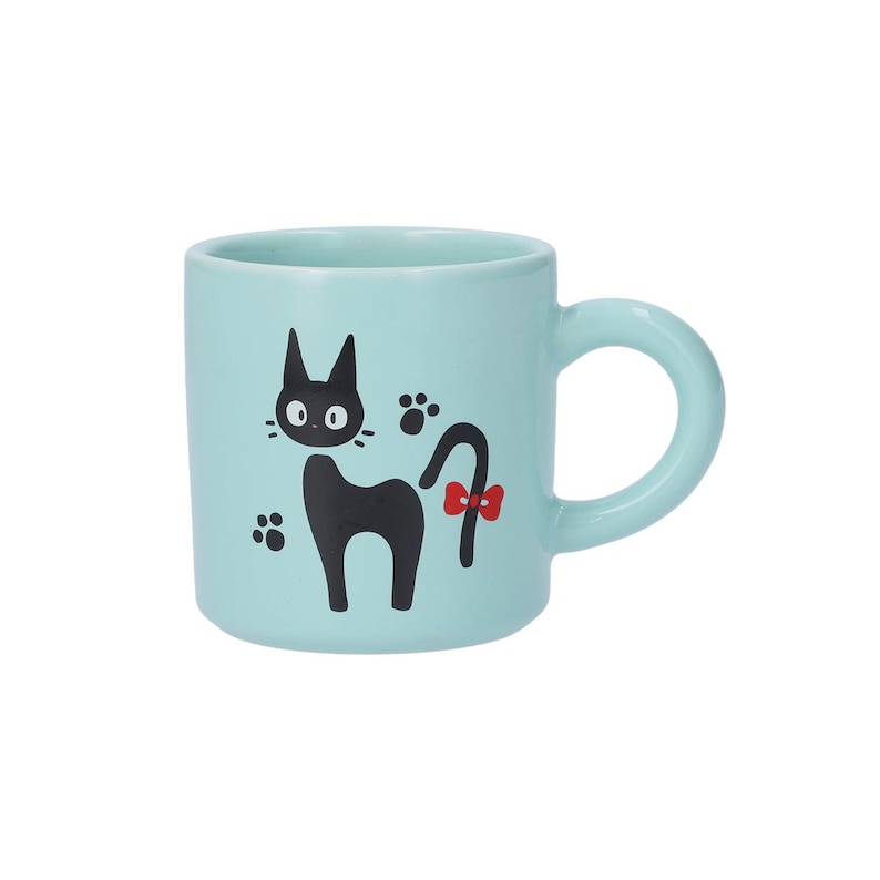 May include: A light blue ceramic mug featuring a black cat illustration with large eyes, a red bow on its tail, and black paw prints. The mug has a smooth, cylindrical body and a rounded handle on the right side, providing a simple, functional design.