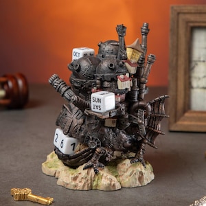 May include: A detailed, steampunk-style perpetual calendar with a dark metallic finish. The calendar features dice for the month, day, and day of the week, along with architectural details and a textured base. A decorative key is in the foreground.