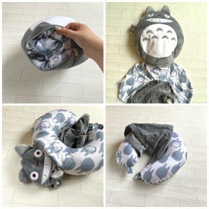 May include: A gray and white travel pillow featuring a cartoon character design. The pillow is gray with a white interior and a zipper closure. The pillow is designed to resemble a popular animated character. The pillow is shown in multiple configurations.