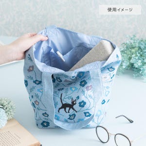 May include: A light blue tote bag with a black cat and floral pattern. The bag has a zippered pocket on the inside and is made of a soft, durable fabric.