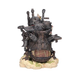 May include: A detailed, steampunk-style sculpture of a mechanical structure with multiple chimneys, gears, and a brick facade. The sculpture is primarily brown and gray, set on a beige base with hints of green.