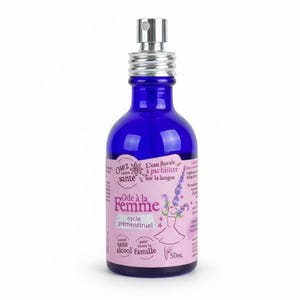 Peut inclure: Une bouteille en verre bleu foncé avec un vaporisateur argenté. L'étiquette présente du texte et un dessin d'une femme en robe. La bouteille contient 50 ml de produit.