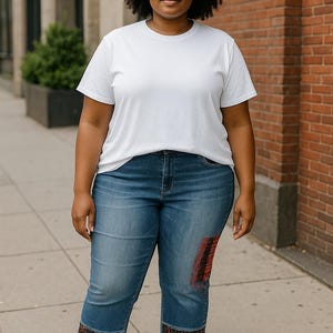 Puede incluir: Una persona con una camiseta blanca, vaqueros cortos azules con parches rojos y negros y sandalias negras. Los vaqueros tienen un estampado decorativo en el dobladillo. El fondo incluye una pared de ladrillo y una acera.