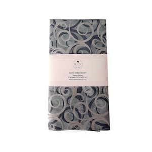 May include: A package of silver anniversary tissue paper. The tissue paper has a swirling pattern in silver and gray. The package is wrapped with a white label that reads "SILVER ANNIVERSARY Tissue Paper 6 sheets (20 in.x30 in.)".