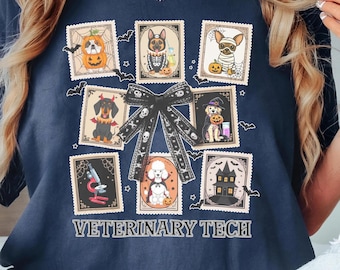 May include: Navy blue t-shirt featuring Halloween-themed dog illustrations in postage stamp designs. The shirt includes a black bow with skull accents and the text "VETERINARY TECH" in white.