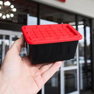 May include: A small rectangular storage container with a solid black base and a vibrant red lid. The lid features a raised grid pattern across its surface, while the black base has a smooth, plain exterior finish for simple organization.