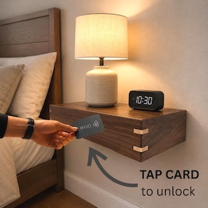 May include: A dark wood floating nightstand with light-colored corner joinery, featuring a table lamp and a digital clock on top. A hand holds a black RFID card near the drawer, with text below reading TAP CARD to unlock and an arrow graphic.