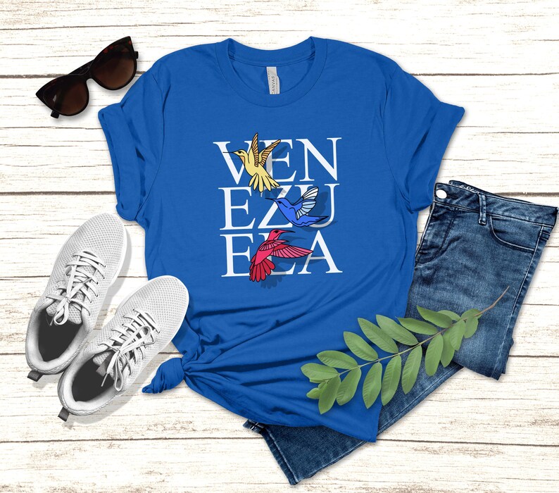 Celebrate Venezuelan pride and hope with our Bella+Canvas 3001 unisex t-shirt. Featuring VENEZUELA with three colorful hummingbirds in yellow, blue, and red, this shirt reflects the flag’s colors and the spirit of freedom. Perfect for Venezuelans abroad who keep their country close to their heart, and for anyone who believes in the message “Hasta el Final, Mano Tengo Fe.” A meaningful gift and a comfortable everyday tee.