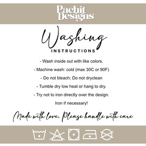 May include: A white card with black text detailing washing instructions. The text advises washing inside out with similar colours, machine washing cold (max 30C), avoiding bleach, tumble drying on low, and avoiding ironing directly on the design. The card also says "Made with love, Please handle with care."