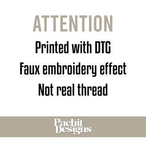 May include: A white background with black and grey text. The text reads "ATTENTION Printed with DTG Faux embroidery effect Not real thread." The bottom of the image has the text "Pachit Designs" in white on a tan background.
