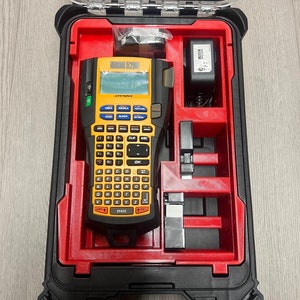 May include: A red and black carrying case with a yellow Dymo Rhino 5200 label maker inside. The case has a handle and a latch. The label maker has a keyboard and a display screen.