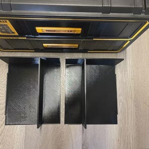 May include: Two black plastic organizers with dividers for a tool box. The organizers are made of a textured plastic and have three compartments each.