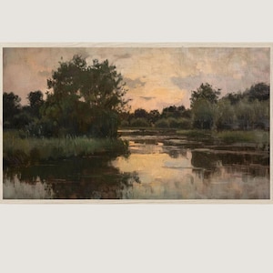 Könnte beinhalten: Ein Landschaftsgemälde in einem hellen Holzrahmen zeigt einen ruhigen Fluss bei Sonnenuntergang. Dunkelgrüne Bäume und grasbewachsene Ufer säumen das Wasser und spiegeln sich darin. Der Himmel ist mit weichen, gedämpften Wolken in Pfirsich- und Grautönen gefüllt.