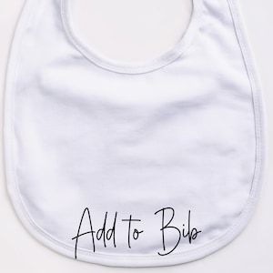 May include: A white baby bib with rounded edges. The bib has the words "Add to Bib" in black script across the bottom. The bib is made of a soft, absorbent material.