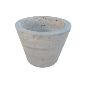 May include: A light gray, round, tapered, stone planter. The planter is made of a rough, textured material.