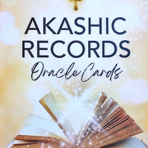 May include: A deck of Akashic Records Oracle Cards with a gold ankh symbol and an open book with glowing light emanating from it. The text on the card reads "Akashic Records Oracle Cards" and "Amanda Romania".
