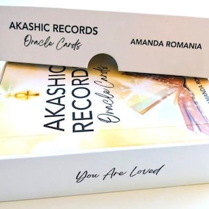Pu&ograve; includere: Scatola bianca con coperchio bianco contenente un mazzo di carte Oracle Akashic Records. La scatola ha il testo "Akashic Records Oracle Cards" e "You Are Loved" stampato su di essa. Il coperchio ha il testo "Akashic Records Oracle Cards" e "Amanda Romania" stampato su di esso.