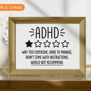 May include: A framed print with a humorous review of ADHD. The print features a one-star rating and the text "ADHD - Way too expensive, hard to manage, didn't come with instructions. Would not recommend."