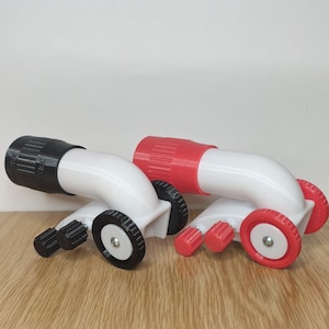 Puede incluir: Dos embudos de laboratorio de plástico blanco con botones y ruedas ajustables negros y rojos. Los embudos están inclinados y tienen un tubo de plástico blanco que conecta la parte superior e inferior.