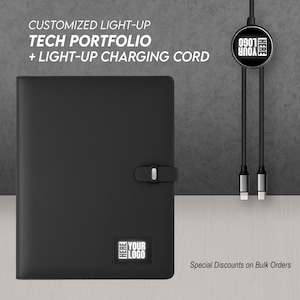 May include: A black tech portfolio with a light-up logo and clasp closure. The image also shows a light-up charging cord. Text on the image reads "CUSTOMIZED LIGHT-UP TECH PORTFOLIO + LIGHT-UP CHARGING CORD" and "YOUR LOGO HERE".