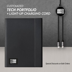 May include: Black tech portfolio with a light-up charging cord. The portfolio has a logo on the front and the text "CUSTOMIZED TECH PORTFOLIO + LIGHT-UP CHARGING CORD". The charging cord has a round logo with the text "HERE YOUR LOGO".