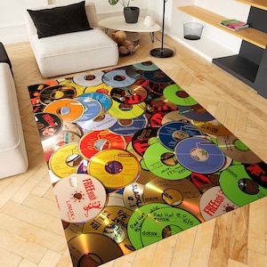 May include: A colourful rug featuring a design of numerous old compact discs. The discs are arranged in a random pattern and have various labels and markings. Some of the labels include "FREEBSD", "LINUX", "Red Hat", and "datax".