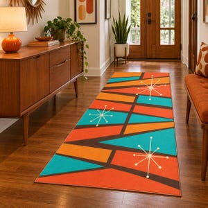 May include: A rectangular runner rug featuring a geometric pattern of orange, teal, and dark brown triangles. The design includes white starburst motifs with thin radiating lines scattered across the surface, creating a repeating mid-century aesthetic.