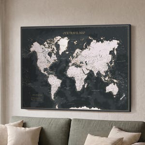 May include: A rectangular wall map titled OUR TRAVEL MAP featuring a dark charcoal background with white continents and landmasses. The map includes detailed geographical labels, grid lines, and a legend in the lower left corner.