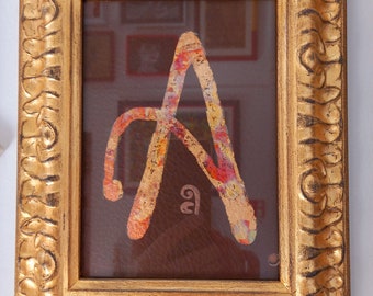 CAPITAL LETTER "A" in gold framed in gold frame