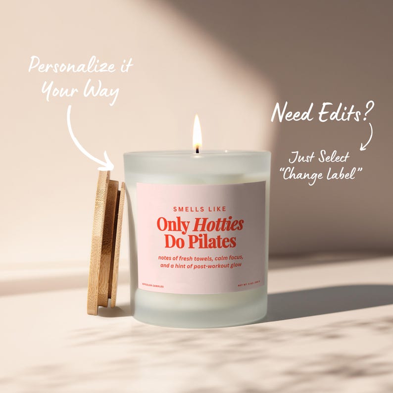 May include: A lit candle in a frosted glass jar with a wooden lid. The label reads "Only Hotties Do Pilates" with scent notes. Text on the image says "Personalize it Your Way" and "Need Edits? Just Select 'Change Label'".