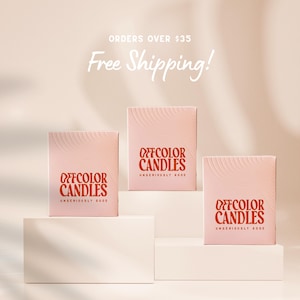 May include: Three pink Offcolor Candles boxes with a wavy design on the front. The boxes have the words "OFFCOLOR CANDLES" in a reddish-orange color, with "UNSERIOUSLY GOOD" below. The background is a light peach color.