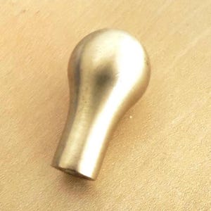May include: A brass-colored cabinet knob with a rounded top and a tapered base. The knob has a smooth, polished finish and is designed for easy gripping. This hardware is suitable for drawers and cabinets.