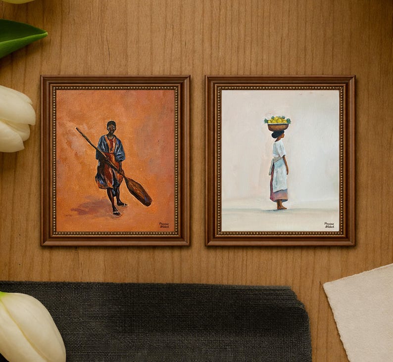 May include: Two framed paintings. The left painting depicts a person holding a large oar, set against an orange background. The right painting shows a person carrying a basket of fruit on their head, set against a white background. Both paintings are in ornate brown frames.