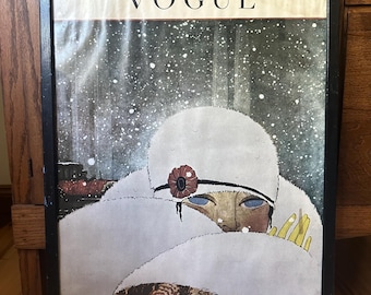 May include: Framed vintage Vogue magazine cover art. The artwork features a woman in a white fur coat and hat, with a red flower accent. The background shows a snowy scene, with the Vogue logo at the top.