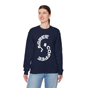 May include: A navy blue sweatshirt with the words "L'AGREE & COFFEE" in white, arranged in a curved design. The sweatshirt is a crew neck style and is being worn by a person.