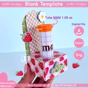 Puede incluir: Un diseño de plantilla en blanco con temática de fresas con el texto "Blank Template" y "Judith Designs". El diseño incluye un tubo de M&M's, un icono de archivo digital y el texto "Tube M&M 30.5 g".