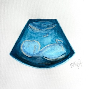 Peut inclure: Une peinture à l'aquarelle d'une image d'échographie bleue. L'image montre un fœtus dans l'utérus. La peinture est signée "Mary Kayle".