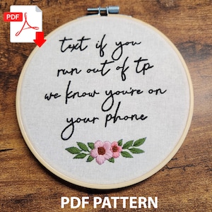 Puede incluir: Arte de bordado en aro con el texto "Text if you run out of tp we know you're on your phone" y un diseño floral con flores rosas y hojas verdes.