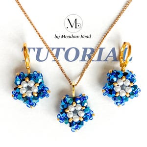 May include: A set of blue and gold beaded jewellery featuring a pendant and earrings. The pendant and earrings are shaped like a star with a white pearl in the centre. The jewellery is on a white background with the text "TUTORIAL" and "by Meadow Bead".