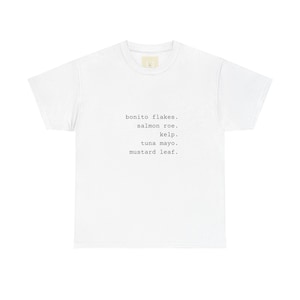 May include: A white short-sleeved t-shirt featuring black typewriter-style text centered on the chest. The text lists five food items: bonito flakes, salmon roe, kelp, tuna mayo, and mustard leaf, each followed by a period on separate lines.