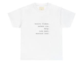 May include: A white short-sleeved t-shirt featuring black typewriter-style text centered on the chest. The text lists five food items: bonito flakes, salmon roe, kelp, tuna mayo, and mustard leaf, each followed by a period on separate lines.