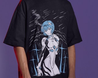 May include: A black t-shirt featuring a graphic print of an anime character with blue hair. The character is wearing a white suit with a black outline. The background is black with white stars.