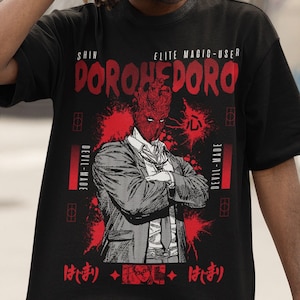 May include: Black t-shirt with a red and white graphic of a character from the anime "Dororo". The graphic includes the text "Shin Elite Magic-User Dororo" and "Devil-Made".