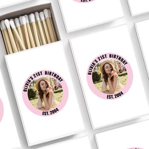 May include: A set of white matchboxes with pink and black text. Each box features a photo of a young woman with the text "Olivia's 21st Birthday Est. 2004".