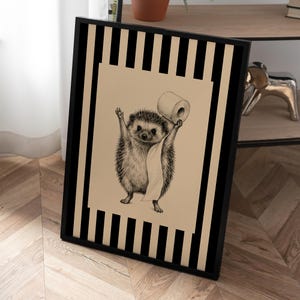 May include: A framed wall art print featuring a black and white illustration of a hedgehog holding a roll of toilet paper. The background consists of vertical black and beige stripes, and the hedgehog is centered on a solid beige rectangular field.