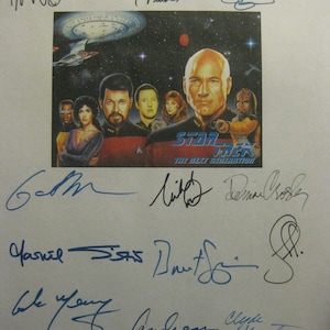 May include: A Star Trek: The Next Generation collectible featuring a color image of the cast with multiple signatures in blue ink. The image includes the show's logo and a space scene.