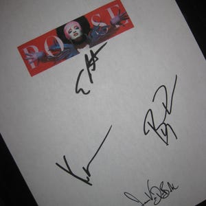 May include: A white paper with the word "POSE" in red, with a picture of a person with pink hair. The paper has multiple black signatures. The image is angled.