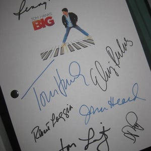May include: A white sheet featuring signatures and a movie poster graphic for the film "Big" starring Tom Hanks. The signatures are in black and blue ink, with the movie title in red and the actor standing on a piano keyboard.